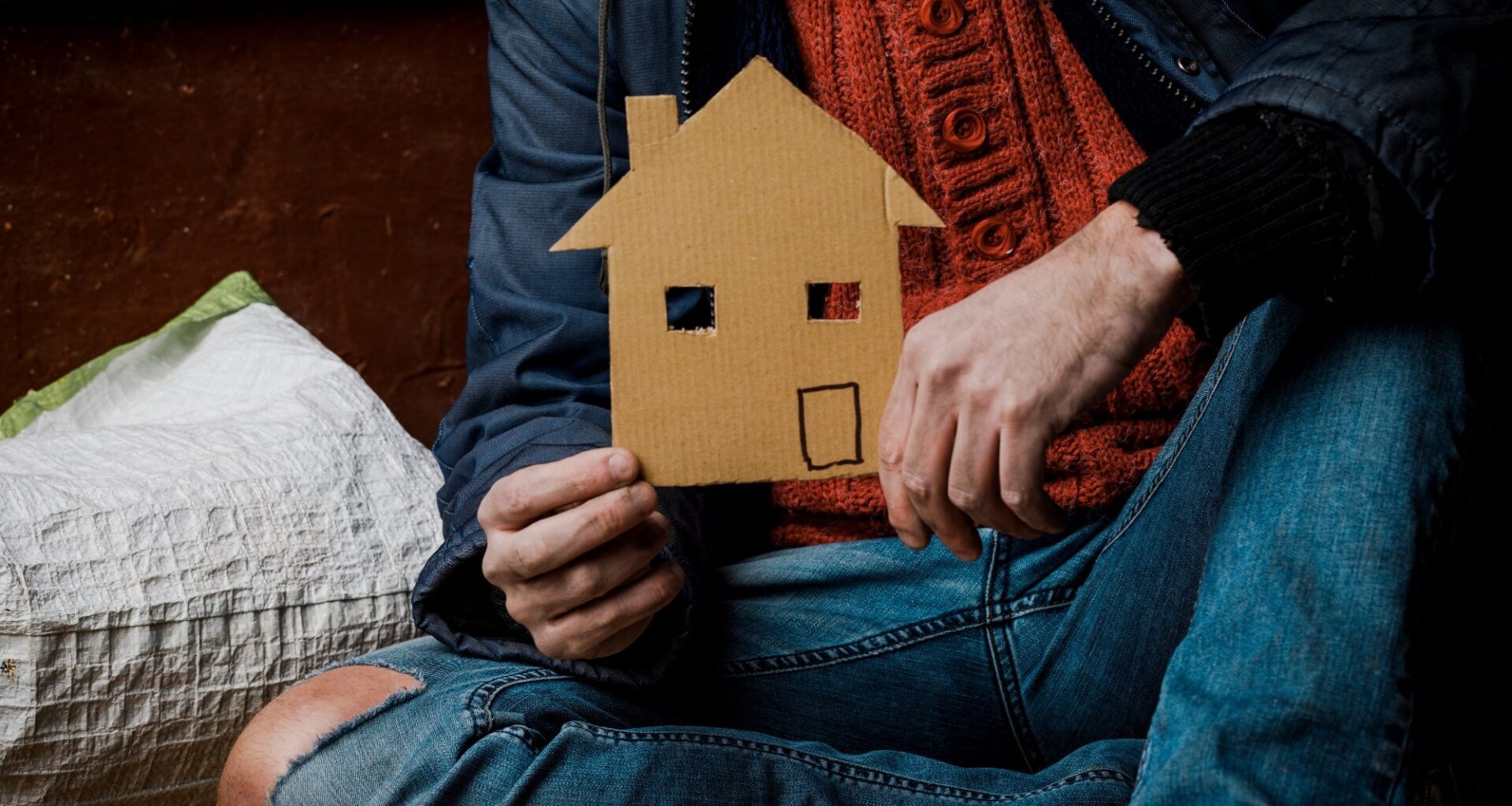 A homeless person holds a sign , asks for work, and seeks help. The concept of poverty and homelessness