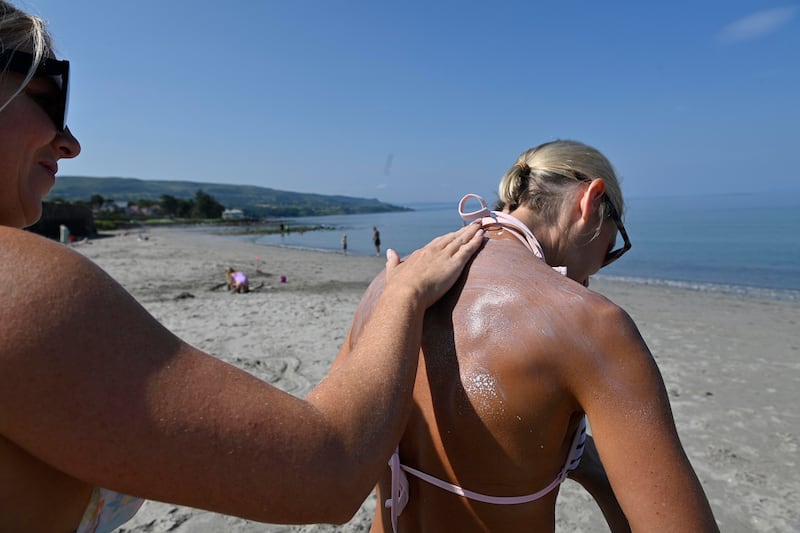 A woman has sun cream applied to her back on the beach near Carnfunnock, Co Antrim. Photograph: Mark Marlow/PA Wire