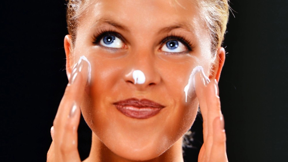 A woman moisturizing her face