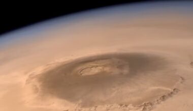Magma systems on Mars: Oblique orbital view of a huge sprawling volcano with a big crater on reddish planet.