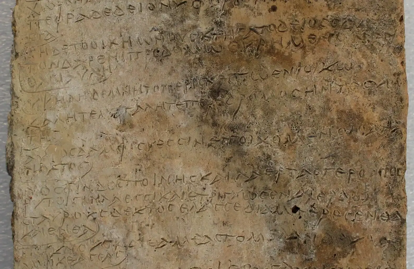 Ancient Greek inscription carved on a weathered stone tablet for historical study.