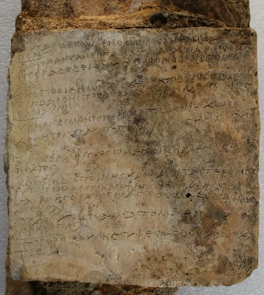 Ancient Greek inscription carved on a weathered stone tablet for historical study.