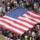 AL KHOR, QATAR - NOVEMBER 25: US fans hold up an American flag before a FIFA World Cup Qatar 2022 Group B match between England and USMNT at Al Bayt Stadium on November 25, 2022 in Al Khor, Qatar. (Photo by Doug Zimmerman/ISI Photos/Getty Images)