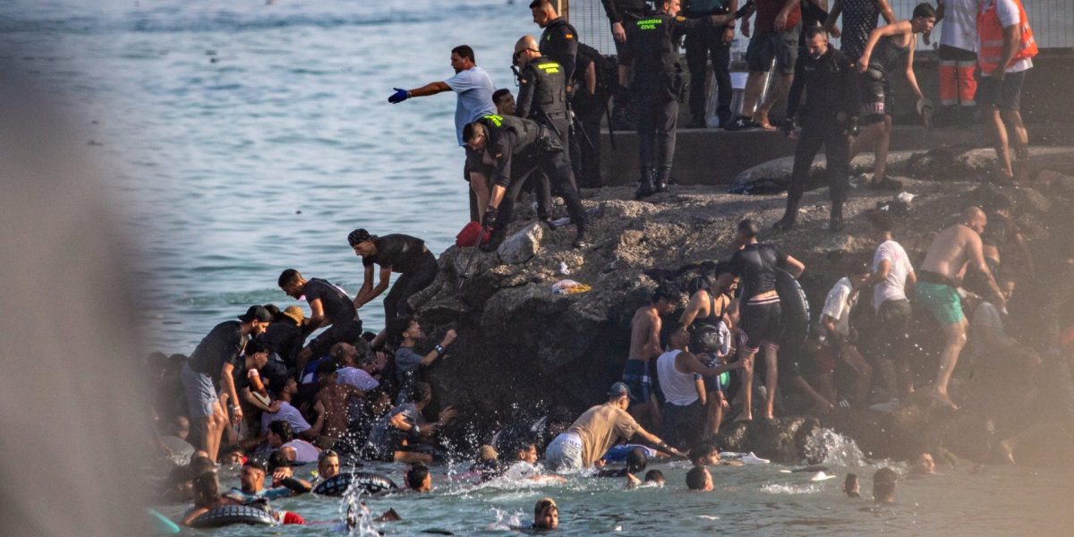Migrants try to cross from Morocco into the Spanish enclave of Ceuta, Thursday, July 30, 2026. (AP Photo/Antonio Sempere)