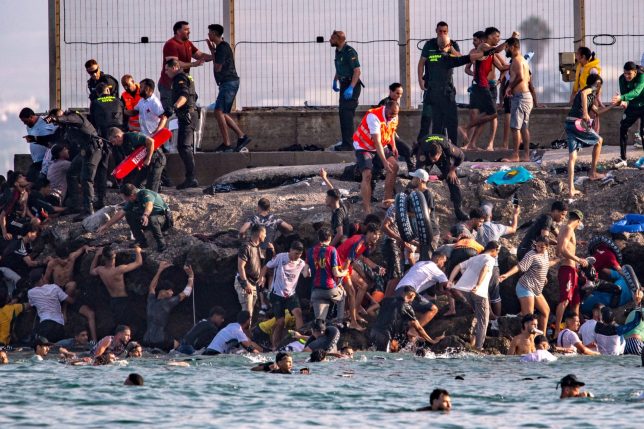 Migrants try to cross from Morocco into the Spanish enclave of Ceuta, Thursday, July 30, 2026. (AP Photo/Antonio Sempere)