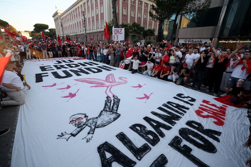 Protesters carry a giant banner which reads 'The end has come. Albania is not for sale' as they demonstrate in front of the Albanian prime minister's office against plans for a luxury resort near a protected natural area.  Photograph: Adnan Beci/AFP/Getty Images
