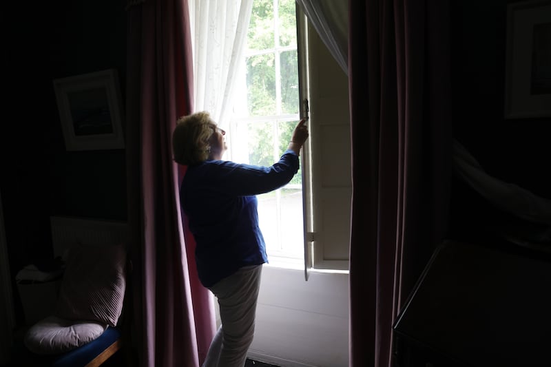 Dr Ina Kelly opens the wooden shutters in her home. The shutters are in place to keep rooms cool during particularly warm spells. Photograph: Bryan O’Brien/The Irish Times