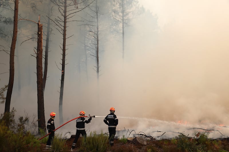 Firefighters spray water towards the wildfire burning in Ares, France. Photograph: Romain Perrocheau/AFP via Getty Images