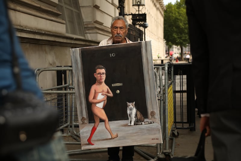 Satirical artist Kaya Mar displays a painting of Andy Burnham on Whitehall in London. Photograph: Alishia Abodunde/Getty Images
