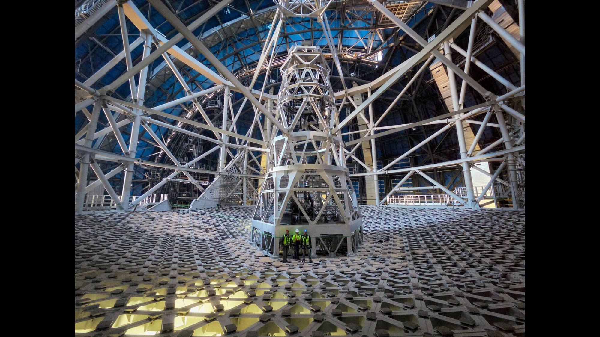 Workers stand near the base of the Extremely Large Telescope.