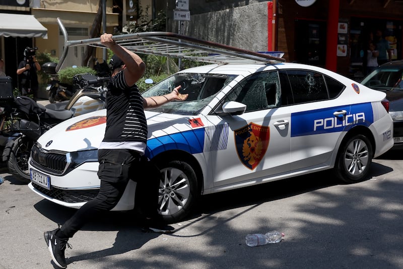 A protester destroys the windscreen of a police car as violent clashes erupted between police and demonstrators on the sidelines of a demonstration against the Kushners' proposed luxury resort development. Photograph: Adnan Beci/AFP via Getty Images