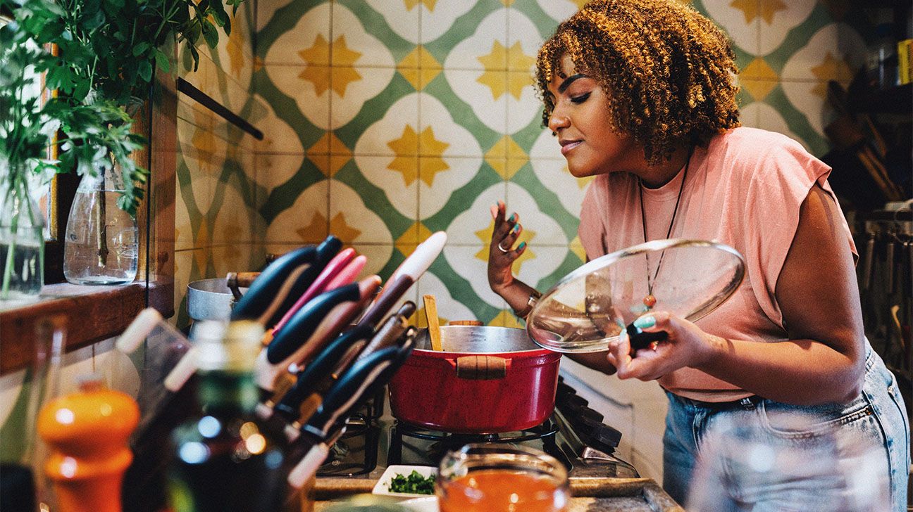 A woman cooking on a stove.