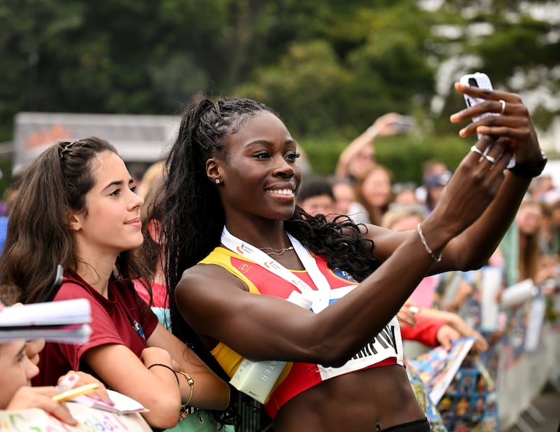 Rhasidat Adeleke takes a photo with a fan after her win in the 200m final. Photograph: Mark Kavanagh/Sportsfile