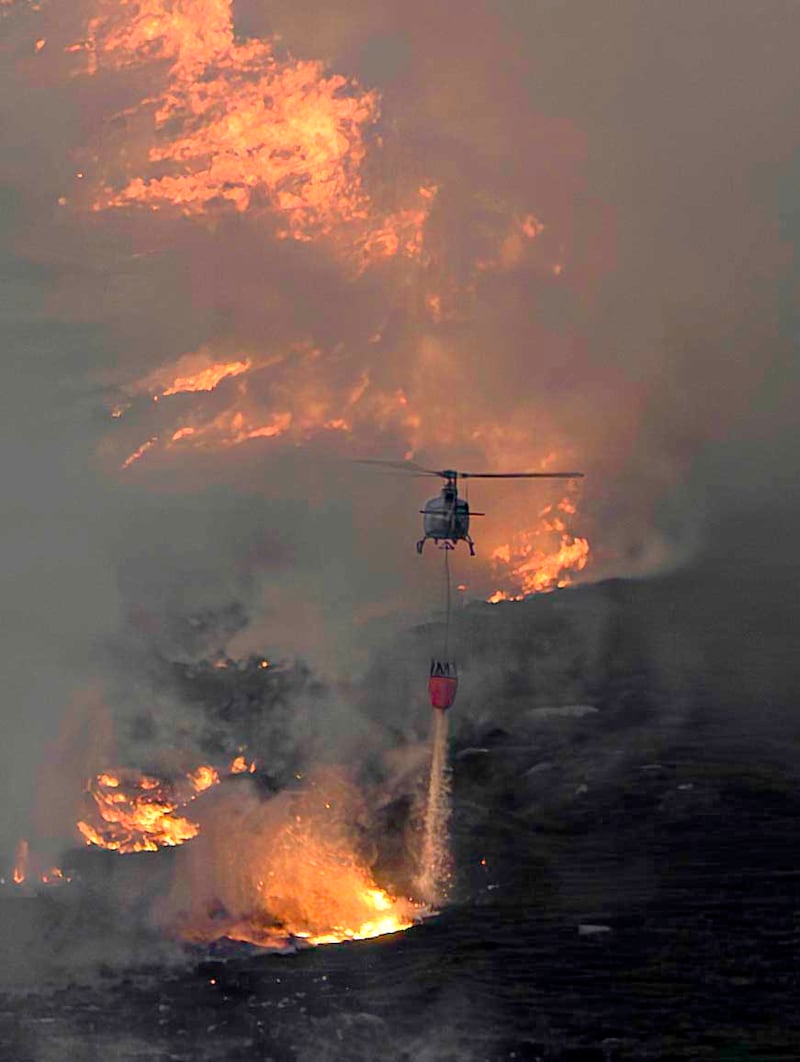 A helicopter drops water on a wildfire on Slievenamon in Co Tipperary on Tuesday July 21st. Firefighters, supported by the Air Corps and Coillte, are continuing efforts to contain the blaze. Photograph: Phil Greaves