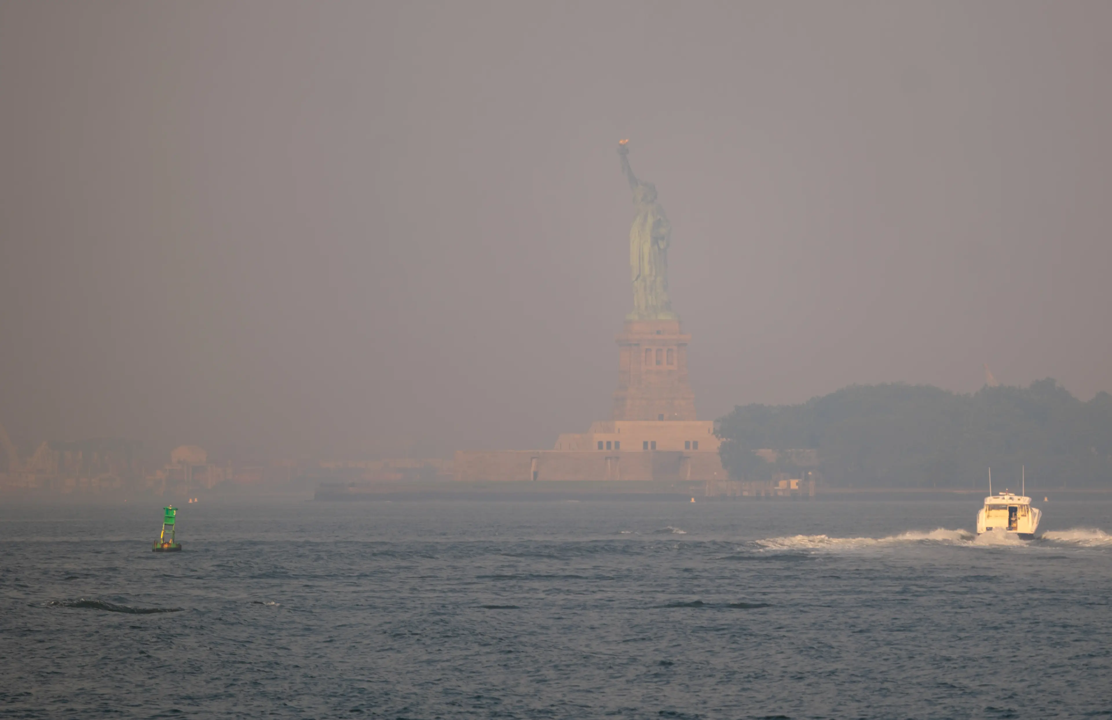 Haze from Canadian wildfires obscures the Statue of Liberty as seen from Brooklyn Bridge Park on July 17, 2026 in New York City. (Getty Images)