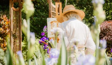 A woman paints on canvas in a sunny garden.