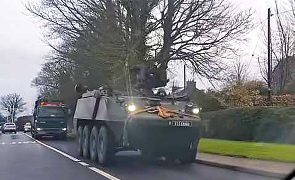 An armoured Defence Forces vehicle being escorted on an Irish road