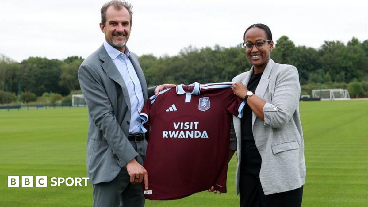 Aston Villa president of business Francesco Calvo and Janet Karemera, CEO of the Rwanda Convention Bureau, hold up an Aston Villa shirt with Visit Rwanda as sponsor