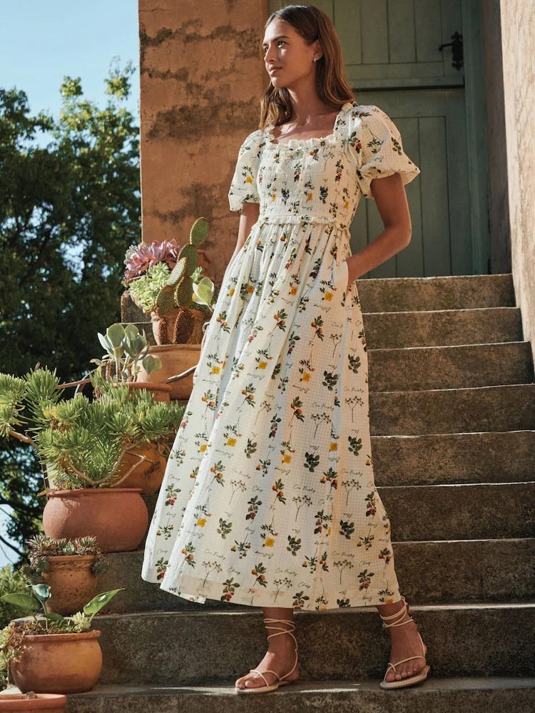 woman in floral dress standing on rustic stone steps with potted plants. woman in floral dress standing on rustic stone steps with potted plants.
