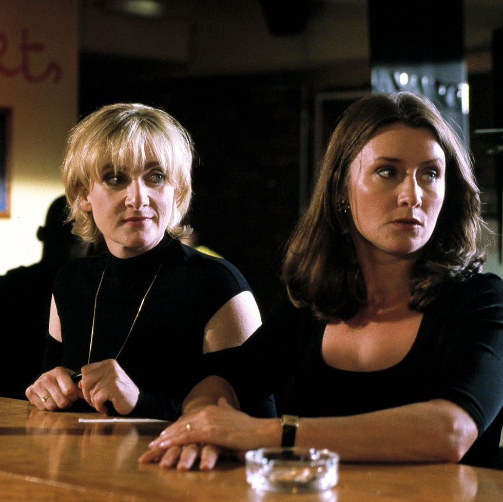 two women sitting at a bar with a blurred background. two women sitting at a bar with a blurred background.