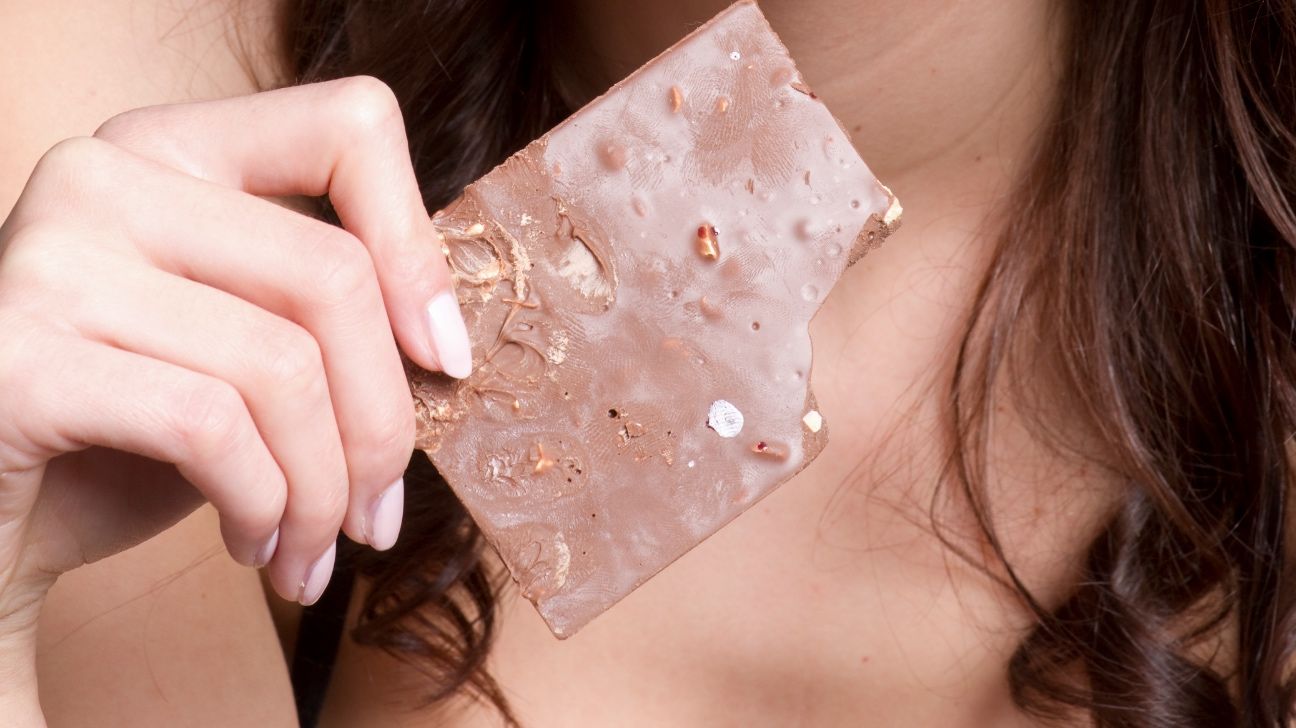 A woman holding a chocolate bar.