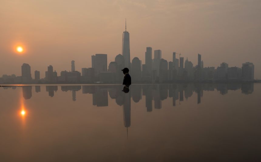 Wildfire smoke shrouds the sunrise over the New York skyline, as seen from Jersey City, New Jersey, on Saturday, July 18.