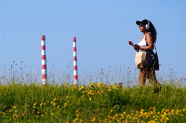 A person walks in the sunshine on Bull Wall in Dublin 