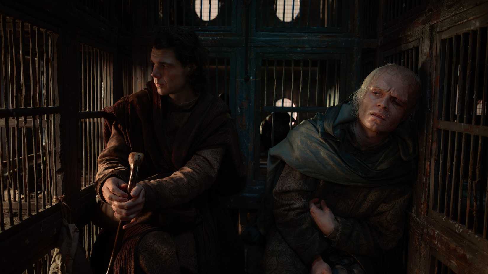 Larys Strong (Matthew Needham) and King Aemond (Tom Glynn-Carney) sit in the back of a carriage filled with bird cages in House of the Dragon season 3