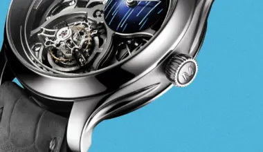 Close-up of a luxury mechanical watch with a polished silver case, visible gears, and a black leather strap against a blue background.