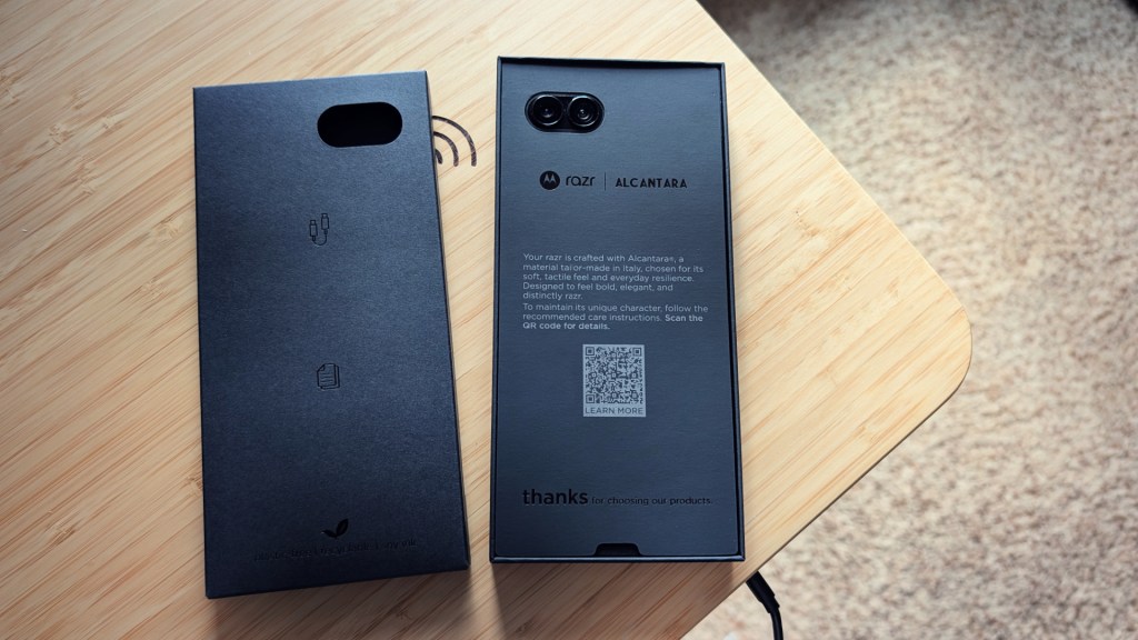 A sleek black packaging box for a smartphone made of Alcantara material, featuring a QR code, camera cutout, and care instructions.