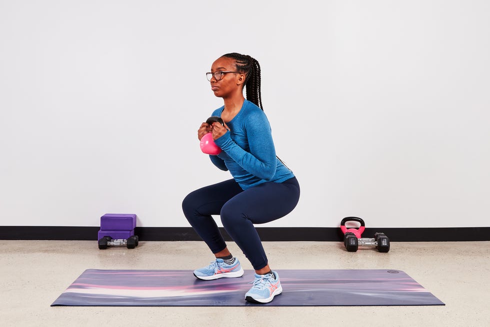 monique lebrun performing a kettlebell squat as part of the transverse abdominis set of exercises
