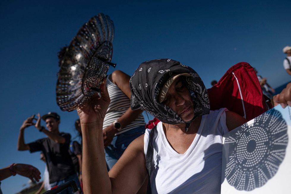 Woman holding a colander to view a solar eclipse in Puerto Rico