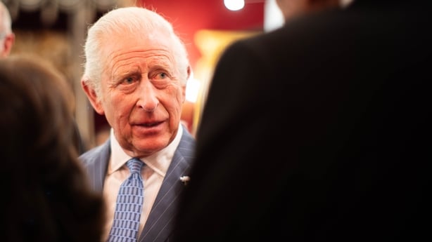 King Charles III speaks with guests at a reception
