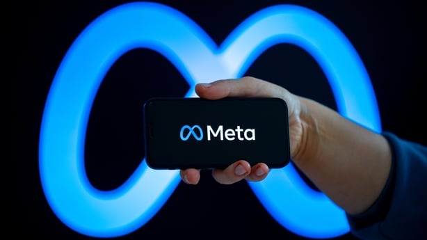 Meta Platforms logo on a smartphone screen with the company logo in the background
