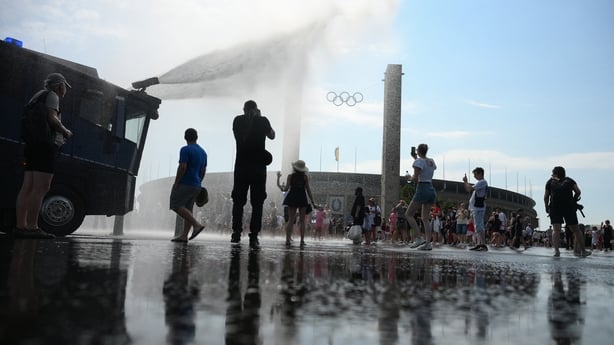 Police use water cannon to spray people with water during high temperatures in Berlin