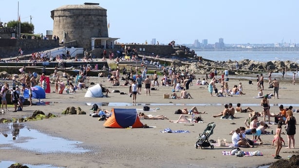 A crowded beach during hot weather in July