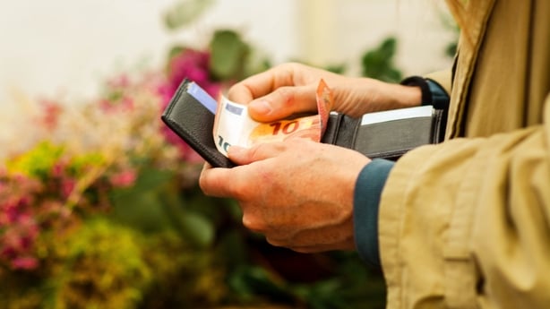 Person removing euro banknotes from a wallet, preparing for a cash payment or transaction