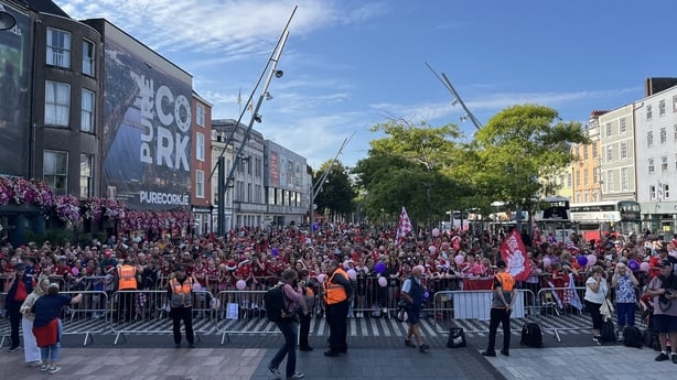 Crowd gather behind a barricade in Cork