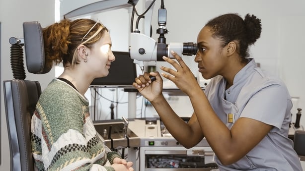 A female doctor doing an eye check on a young woman