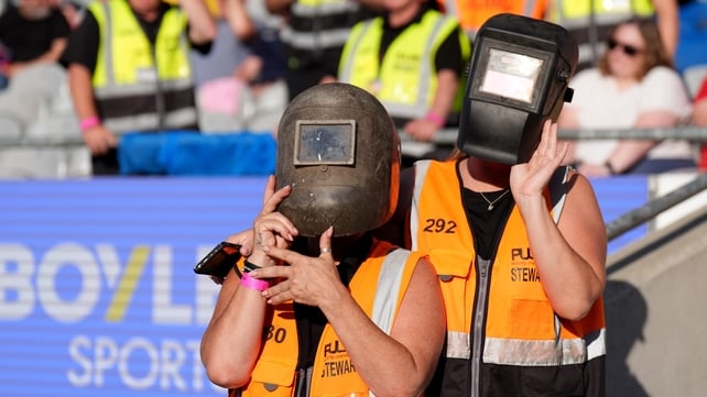 Stewards wearing welding helmets to watch the solar eclipse