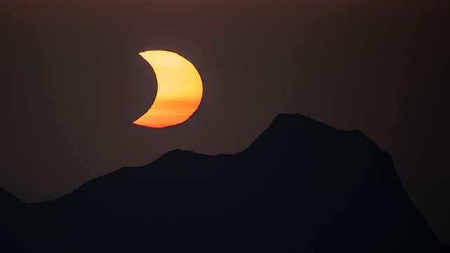 The moon obscures the sun above the summit of Gantrisch during a partial solar eclipse on Wednesday, Aug. 12, 2026, seen from the summit of the Niesen mountain in the Bernese Oberland in Switzerland