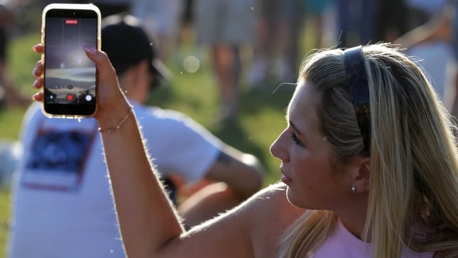 Katrina Pashko from Dublin 15 watches the eclipse from her phone. Pic: Collins
