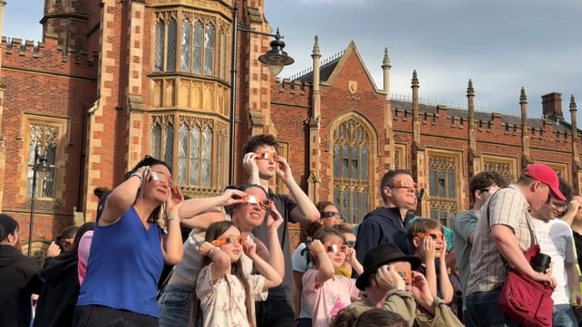People gather to watch the solar eclipse outside Queen's University in Belfast