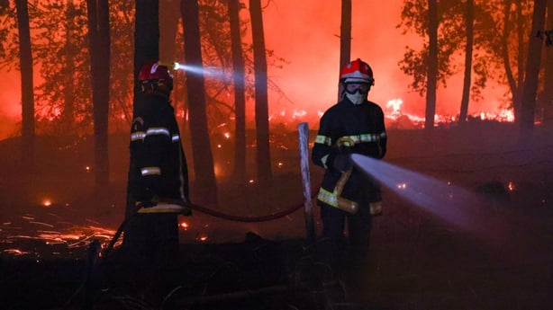 Firefighters battle the flames as a wildfire