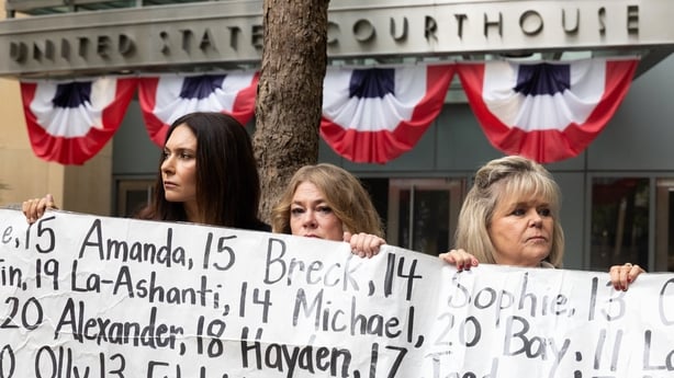 OAKLAND, CALIFORNIA - AUGUST 18: (L-R) Lisa Pearson, Victoria Hinks and Lori Schott hold a banner displaying names of people that allegedly died from impacts of social media stand with a banner outside the Ronald V. Dellums Federal Building and U.S. Courthouse on August 18, 2026 in Oakland, Californ