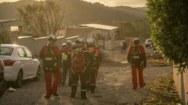 Firefighters conduct search operations amid destroyed houses