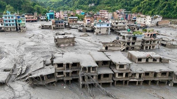 an aerial view shows houses lying deluged in sludge after flash floods