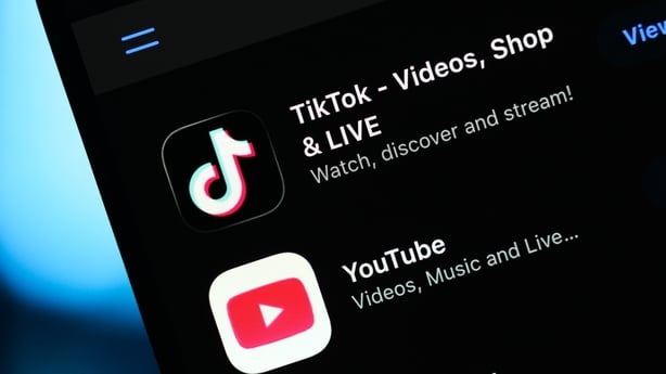 TikTok and YouTube logos are seen displayed on a smartphone screen