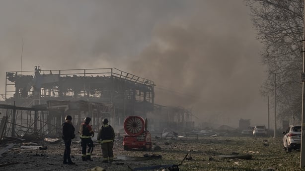 Emergency service workers and local authorities respond to a Russian strike in the Bucha district in Kyiv