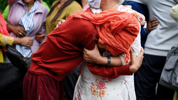 People mourn their missing relatives in the aftermath of flash floods, outside a mortuary in Nepal's Chitwan district